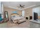 Relaxing bedroom features a tray ceiling, a ceiling fan, a fireplace, and soft carpet at 333 Dudley Dr, Fort Mill, SC 29715