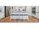 Modern white kitchen features stainless steel appliances, large island with seating, and hardwood floors at 333 Dudley Dr, Fort Mill, SC 29715
