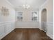 Elegant dining room with wainscoting, hardwood floors, and a modern chandelier at 3615 Slider Ter, Lancaster, SC 29720