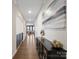 Long hallway with hardwood floors, white walls, a console table, and decorative art at 3615 Slider Ter, Lancaster, SC 29720