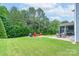 Expansive backyard with lush green grass, an outdoor dining area, and a cozy firepit at 3666 Jacinta Ct, Tega Cay, SC 29708