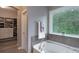 Relaxing bathroom with a soaking tub, large window with wooded views, and a spacious closet at 3666 Jacinta Ct, Tega Cay, SC 29708