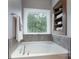 Bright bathroom showcasing a soaking tub beneath a window offering private backyard views at 3666 Jacinta Ct, Tega Cay, SC 29708