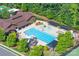 Aerial view of the community pool with a slide, area, lounge chairs, umbrellas, and trees at 3666 Jacinta Ct, Tega Cay, SC 29708