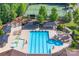 Aerial view of a community pool featuring a slide, area, umbrellas, lounge chairs, and tennis court at 3666 Jacinta Ct, Tega Cay, SC 29708