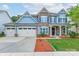 Charming two-story home with stone accents, inviting front porch, three car garage and manicured lawn at 3666 Jacinta Ct, Tega Cay, SC 29708