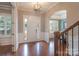 Elegant foyer with hardwood floors, wainscoting, arched doorways, and stylish light fixture at 3666 Jacinta Ct, Tega Cay, SC 29708