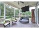 Charming screened porch offering comfortable seating, a mounted television, and serene backyard views at 3666 Jacinta Ct, Tega Cay, SC 29708