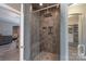 Modern bathroom shower featuring tiled walls, a rainfall showerhead, and built-in shelving at 3666 Jacinta Ct, Tega Cay, SC 29708