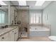 Elegant bathroom features a soaking tub, glass shower, double vanity, and skylight at 4101 Fairway Downs Ct # 9, Charlotte, NC 28277