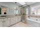 Modern bathroom featuring a soaking tub, glass shower, double vanity, and neutral tile at 4101 Fairway Downs Ct # 9, Charlotte, NC 28277