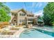 Expansive backyard featuring a sparkling pool, lounge chairs, dining area, and lush landscaping at 4319 Sailview Dr, Denver, NC 28037