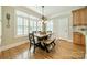 An eat-in kitchen features a dining table set in front of a sunny window and wood floors at 4319 Sailview Dr, Denver, NC 28037