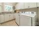 Functional laundry room with white cabinets, granite countertops, a sink, and modern washer and dryer at 4319 Sailview Dr, Denver, NC 28037