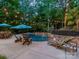 Backyard swimming pool with lounge chairs, patio furniture, lush landscaping, and outdoor string lights at 4319 Sailview Dr, Denver, NC 28037