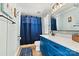 Bathroom with a bright blue vanity, a shower with blue curtain, and modern fixtures at 4920 Longfield St, Claremont, NC 28610