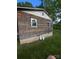 Side view of rustic cabin with aged wood siding, small windows, and a concrete foundation at 5040 Fairview Church Rd, Lincolnton, NC 28092