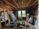 Unfinished interior showcasing exposed beams, window frames, and various construction materials at 5040 Fairview Church Rd, Lincolnton, NC 28092