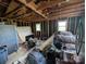 Cluttered interior with exposed beams, unfinished walls, and household items piled throughout at 5040 Fairview Church Rd, Lincolnton, NC 28092
