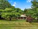 Serene view of a home surrounded by lush greenery and blue skies at 511 Apple Ln, Bessemer City, NC 28016
