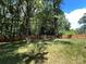 Large, grassy backyard with a tall wood privacy fence and mature trees at 511 Evelyn Ave, Kannapolis, NC 28083