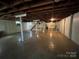 Unfinished basement with concrete floor, exposed ceiling, support beams, and stairs to main floor at 511 Evelyn Ave, Kannapolis, NC 28083