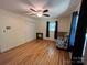 Cozy bedroom with hardwood floors, ceiling fan, and a comfortable chair at 511 Evelyn Ave, Kannapolis, NC 28083
