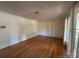 This bedroom has hardwood floors, white walls, a radiator, and a window with curtains at 511 Evelyn Ave, Kannapolis, NC 28083