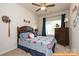 Baseball-themed bedroom featuring a wood-trimmed bed, a ceiling fan, and a window letting in natural light at 6024 Jasmine Branch Rd, Charlotte, NC 28216