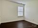 Bright bedroom features hardwood floors, a window, and neutral paint at 710 Woodington Ln, Charlotte, NC 28214