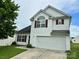 Charming two-story home featuring white siding, red shutters, and an attached two-car garage at 710 Woodington Ln, Charlotte, NC 28214