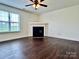 Bright living room offers a classic fireplace, hardwood floors, and ceiling fan at 710 Woodington Ln, Charlotte, NC 28214