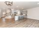 Open living area with a kitchen island, modern light fixture, and staircase at 724 Little Bluestem Dr, Lake Wylie, SC 29710