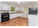 Functional kitchen with white cabinets, laminate flooring, and essential appliances at 730 Marble St, Charlotte, NC 28208