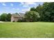 Expansive backyard with lush green lawn and mature trees surrounding the home at 803 Freeman Rd, Concord, NC 28025