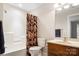 Bathroom with shower/tub combo, floral curtain, wood vanity, and large mirror at 803 Freeman Rd, Concord, NC 28025