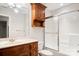 Bright bathroom featuring a wood vanity, large mirror, and shower with glass doors at 803 Freeman Rd, Concord, NC 28025