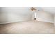 Large carpeted bonus room with sloped ceiling, ceiling fan, and open doorway at 803 Freeman Rd, Concord, NC 28025