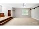 A spacious bonus room with staircase platform, built-in shelves, and large window at 803 Freeman Rd, Concord, NC 28025