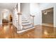 Classic entryway with hardwood floors, carpeted stairs, and white railings, offering a welcoming ambiance at 803 Freeman Rd, Concord, NC 28025