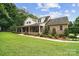 Charming two-story brick home with a large front porch, lush lawn, and mature landscaping at 803 Freeman Rd, Concord, NC 28025