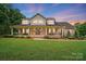Charming two-story brick home with a large front porch, lush lawn, and beautiful landscaping at 803 Freeman Rd, Concord, NC 28025