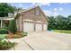 Three-car garage with brick facade, white doors, and well-maintained landscaping at 803 Freeman Rd, Concord, NC 28025