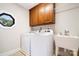 Bright laundry room features cabinetry above the washer and dryer and a utility sink with faucet at 803 Freeman Rd, Concord, NC 28025