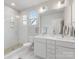 Bright bathroom with a double vanity, glass-enclosed shower, and modern fixtures at 933 E 36Th St, Charlotte, NC 28205