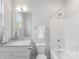 Clean bathroom with a bathtub shower combo, single sink vanity, and updated fixtures at 933 E 36Th St, Charlotte, NC 28205