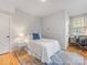 Cozy bedroom with hardwood floors, a comfortable bed, and a dedicated workspace by the window at 933 E 36Th St, Charlotte, NC 28205