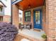 Cozy front porch with brick accents, comfortable seating, and a welcoming blue door at 933 E 36Th St, Charlotte, NC 28205