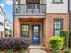 Charming brick front porch with a blue door, complemented by potted flowers and lush greenery at 933 E 36Th St, Charlotte, NC 28205