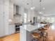 Bright kitchen features an island with seating, stainless steel appliances, and white cabinetry at 933 E 36Th St, Charlotte, NC 28205
